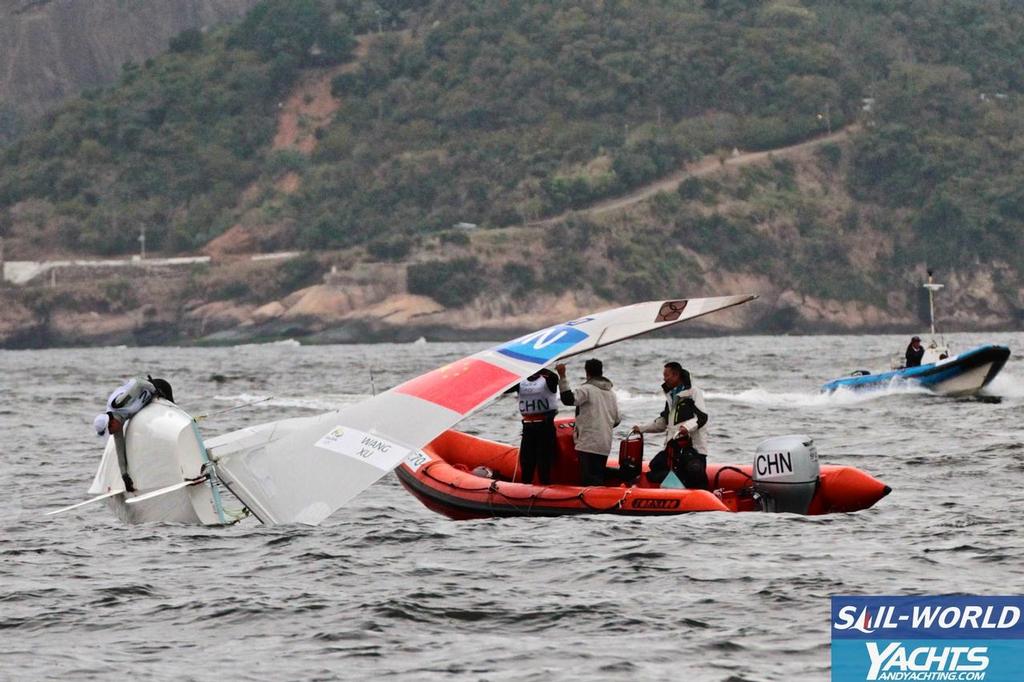 Chinese men address a centreboard slot issue before the start of racing © Richard Gladwell www.photosport.co.nz